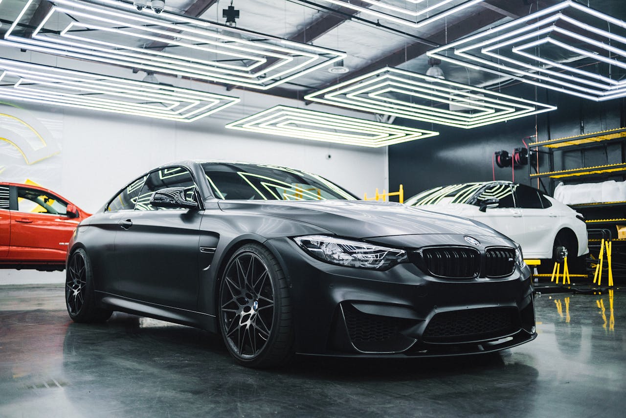 Luxury black car showcased in a modern garage setting, highlighting its sleek design and elegance.